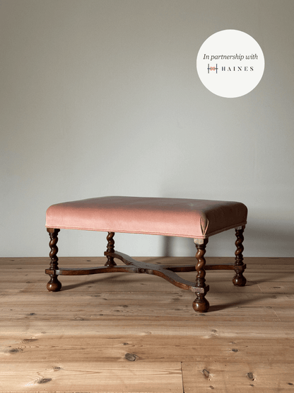 Antique footstool raised on barley twist supports