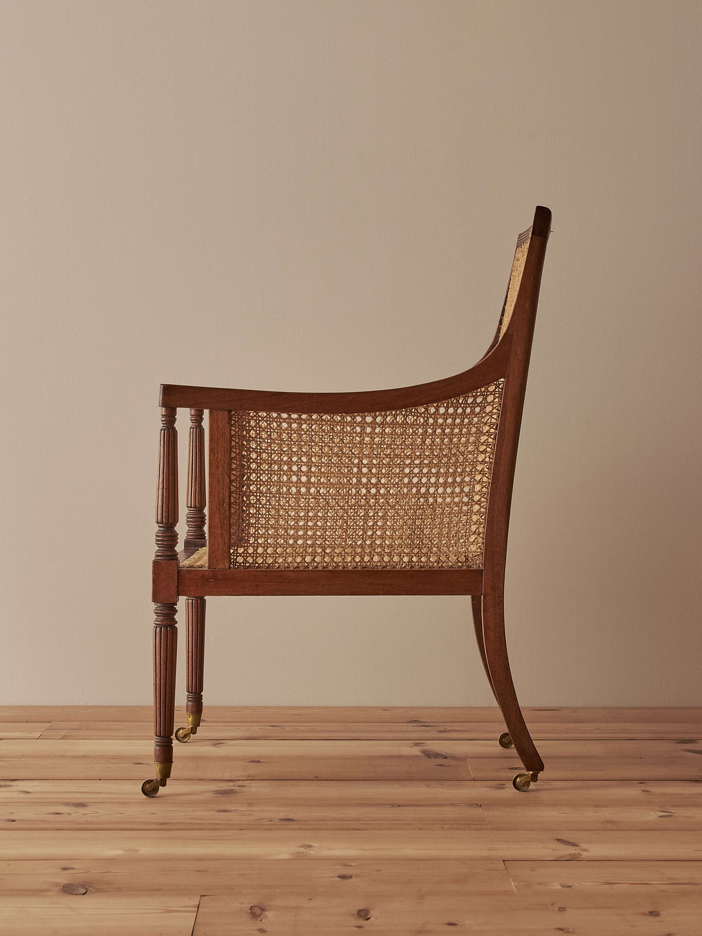 Pair of antique bergère chairs raised on brass castors