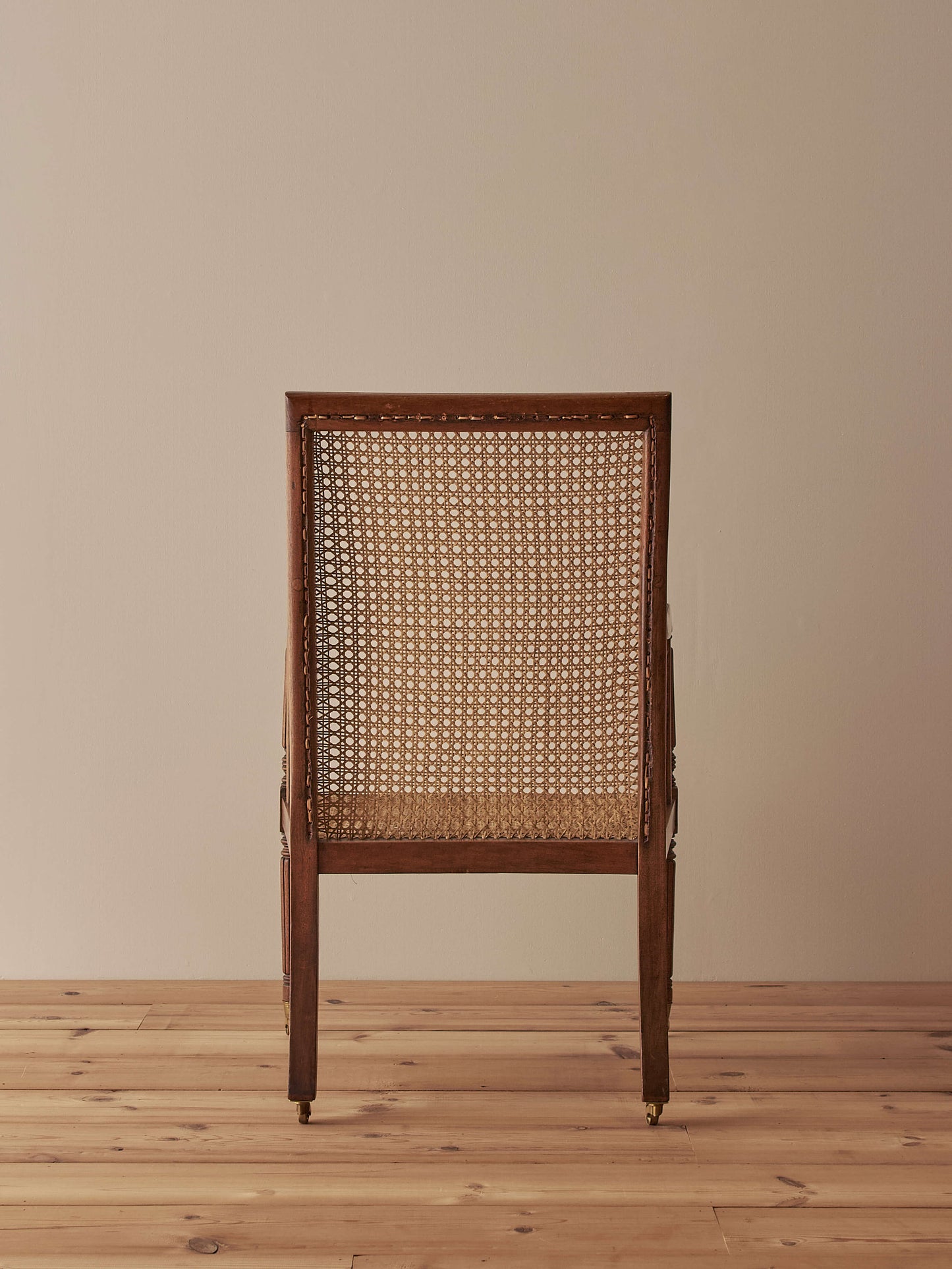 Pair of antique bergère chairs raised on brass castors