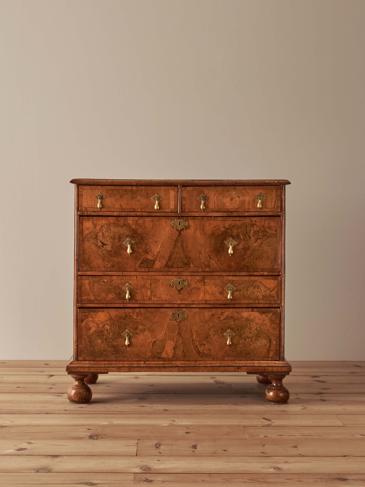 Queen Anne walnut chest of drawers raised on bun feet