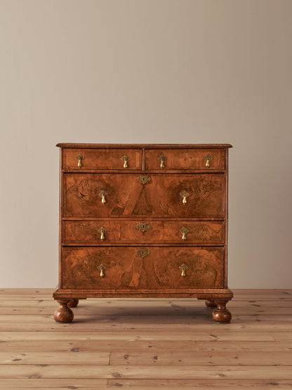 Queen Anne walnut chest of drawers raised on bun feet