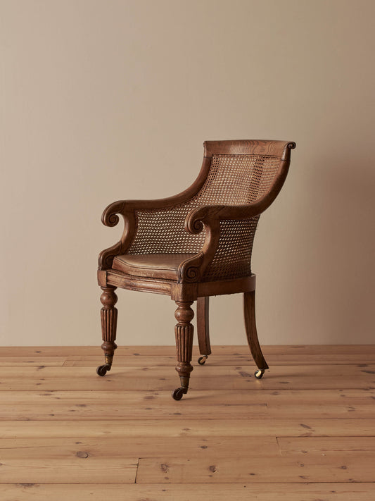 William IV oak bergère chair raised on castors