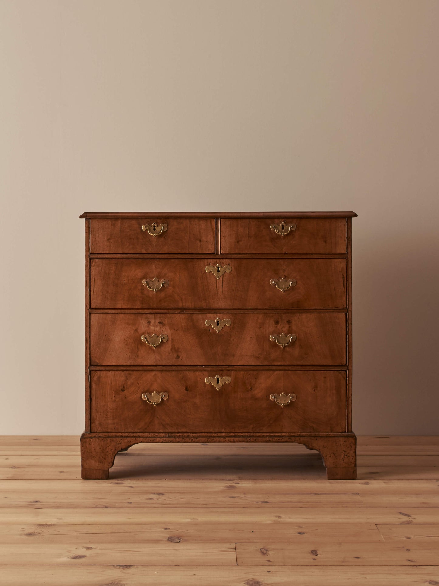 Georgian walnut chest of drawers raised on bracket feet