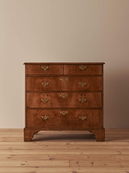 Georgian walnut chest of drawers raised on bracket feet