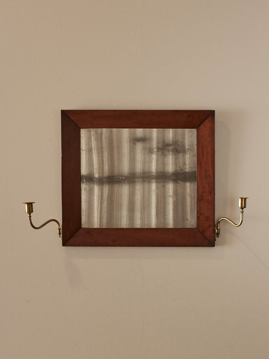 Antique walnut mirror flanked with brass candle sconces