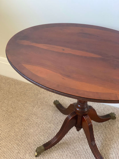 Vintage oval occasional table with brass claw feet