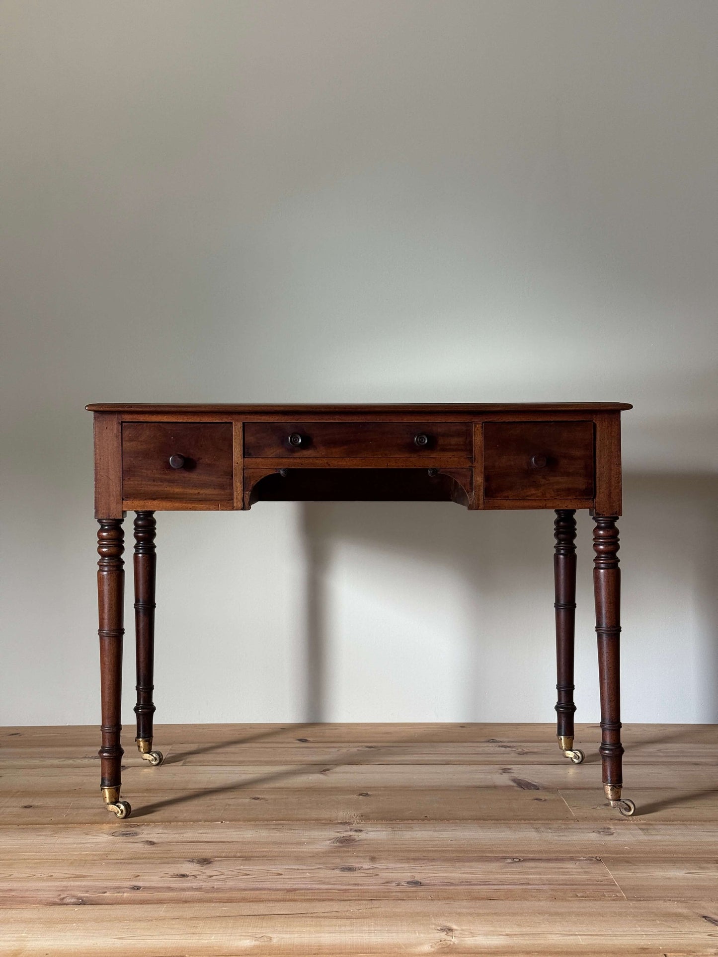 Regency mahogany desk on brass castors