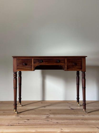Regency mahogany desk on brass castors