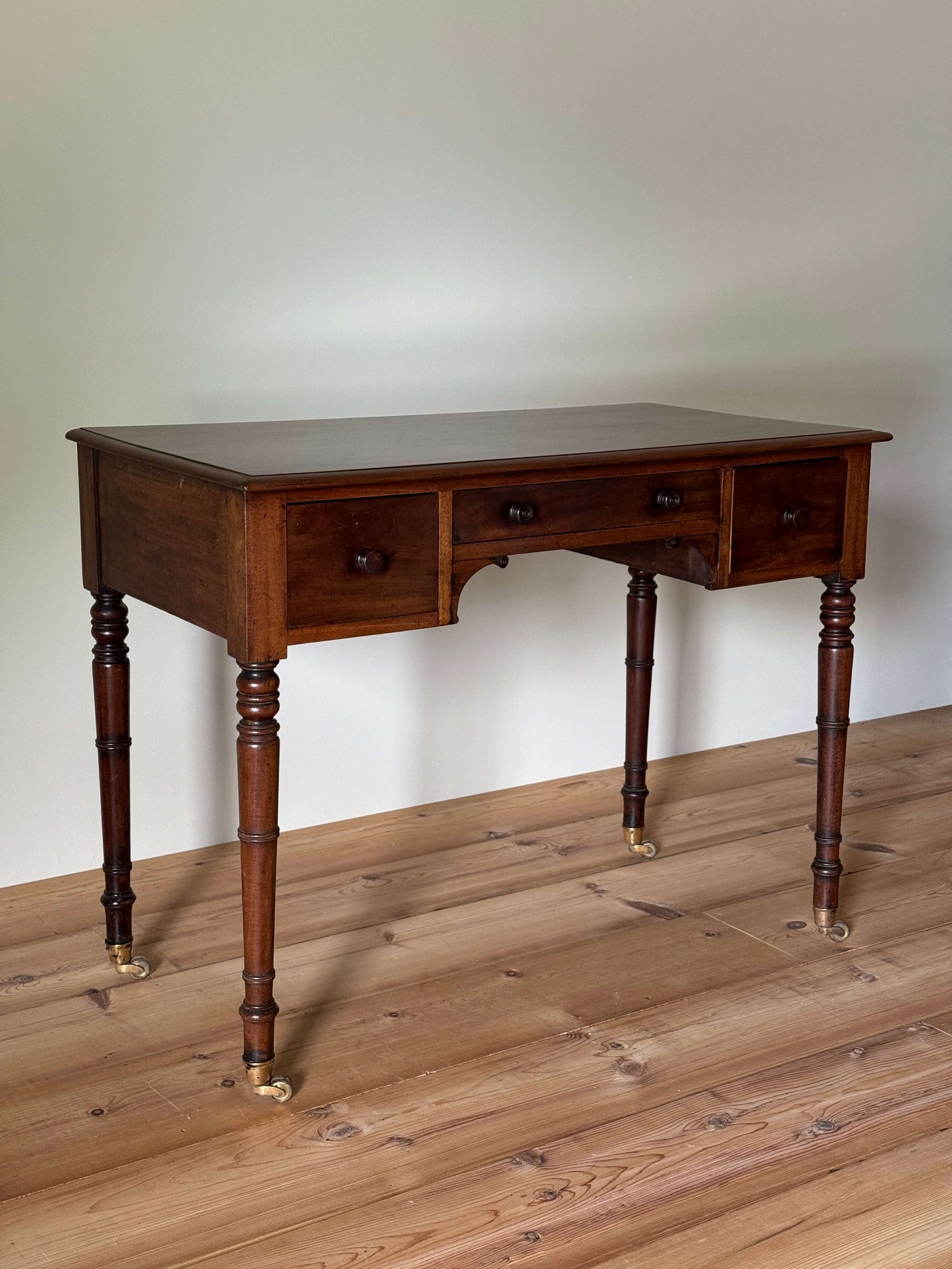 Regency mahogany desk on brass castors