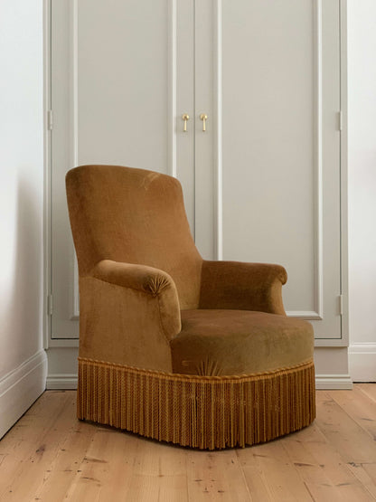 French antique yellow armchair with tasseled skirt