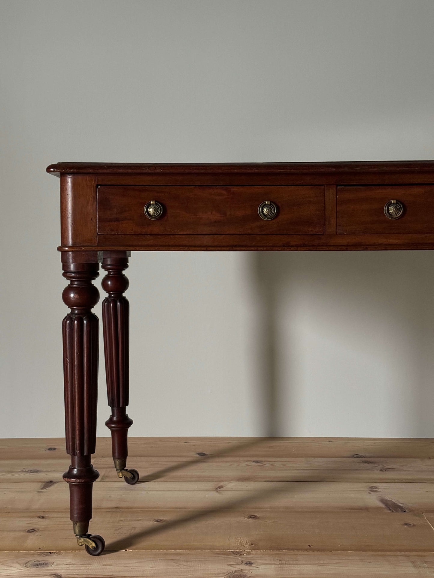 Regency mahogany writing desk on fluted legs and brass casters