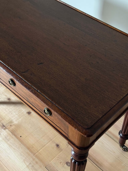 Regency mahogany writing desk on fluted legs and brass casters