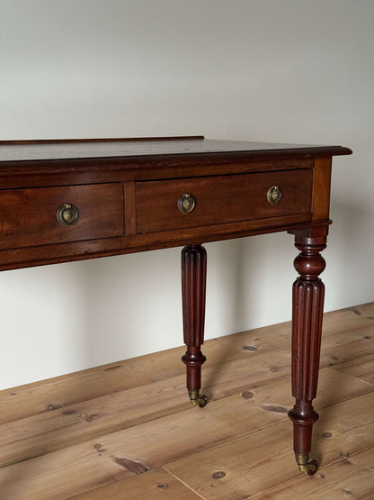 Regency mahogany writing desk on fluted legs and brass casters