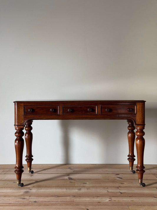 Antique Victorian mahogany writing desk on brass casters