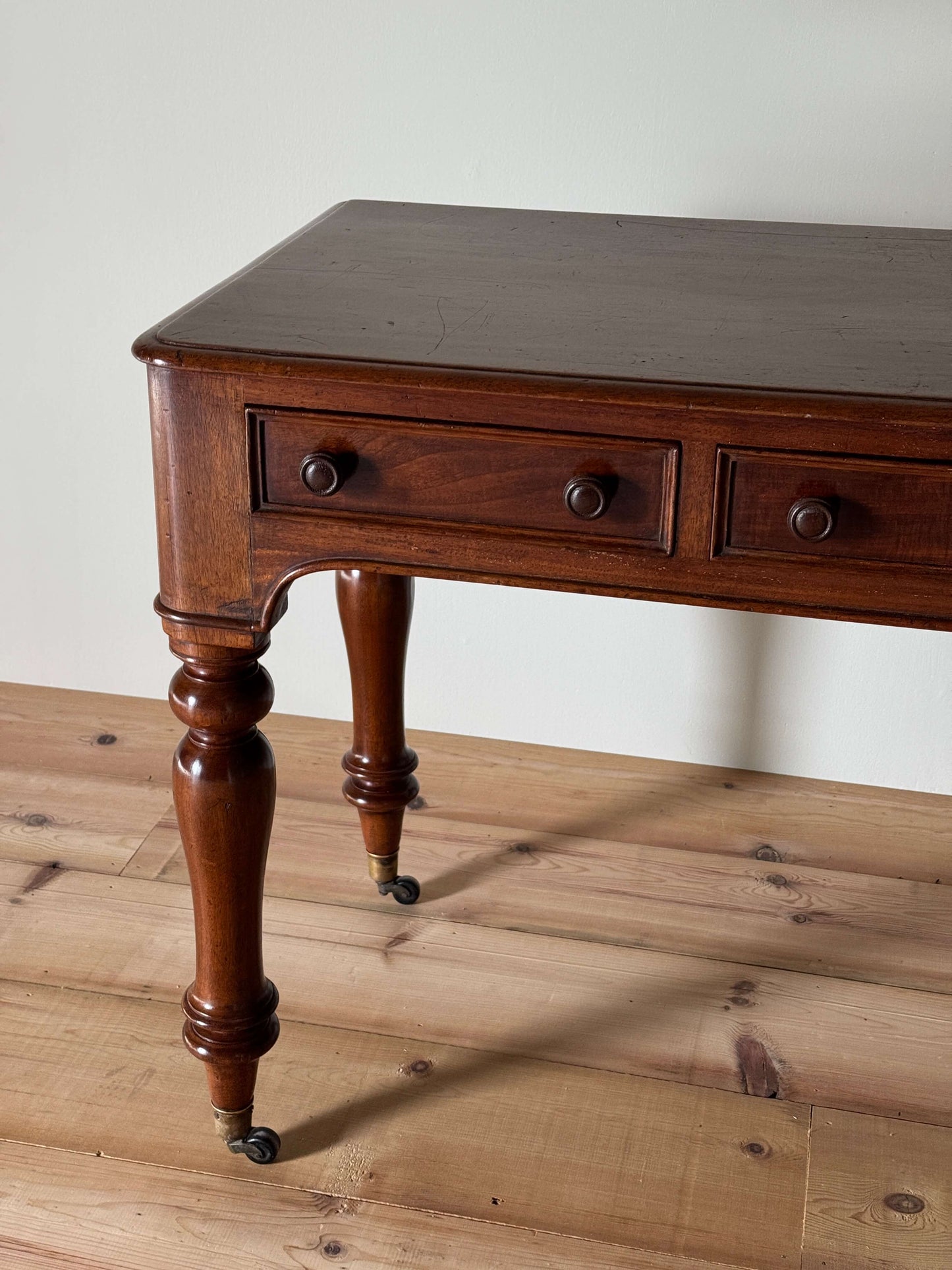 Antique Victorian mahogany writing desk on brass casters