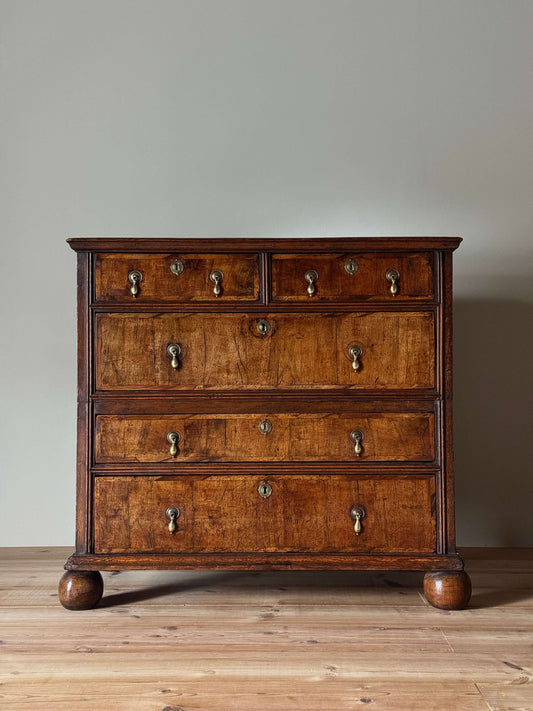 Queen Anne walnut chest of drawers raised on bun feet