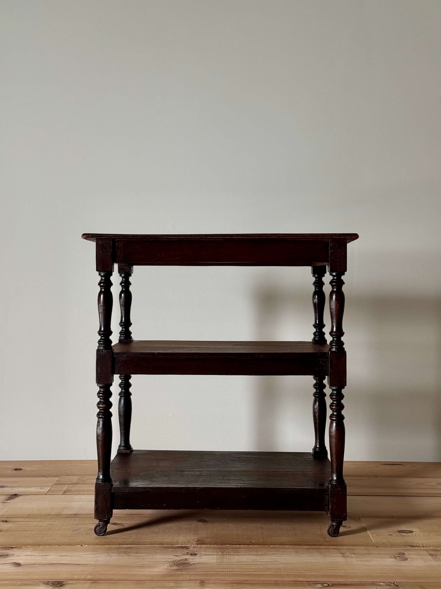 Edwardian three-tiered table on casters