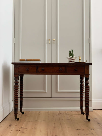 Antique bobbin console table on brass casters