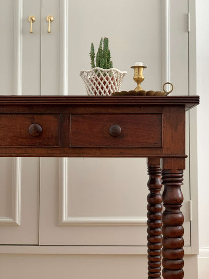 Antique bobbin console table on brass casters