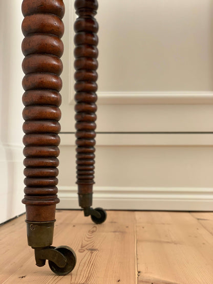 Antique bobbin console table on brass casters