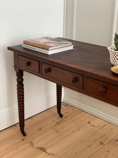 Antique bobbin console table on brass casters